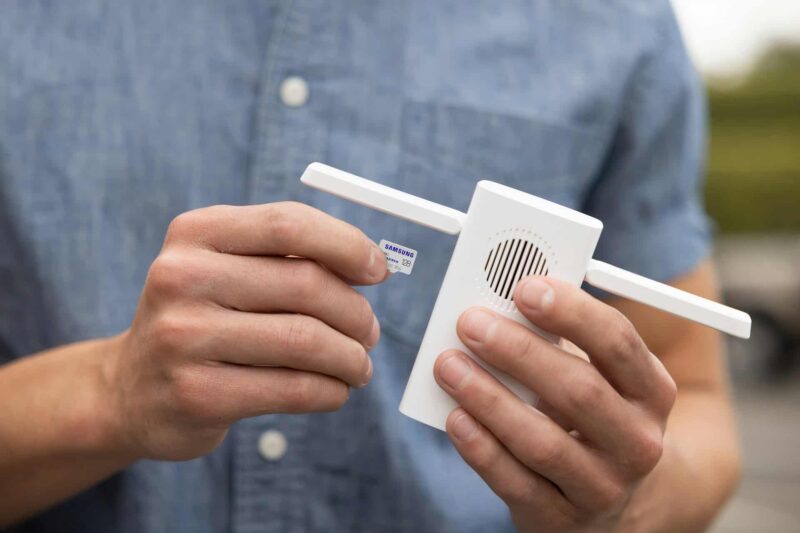 A man holding a WiFi signal booster, one of the broadband extras offered by many suppliers