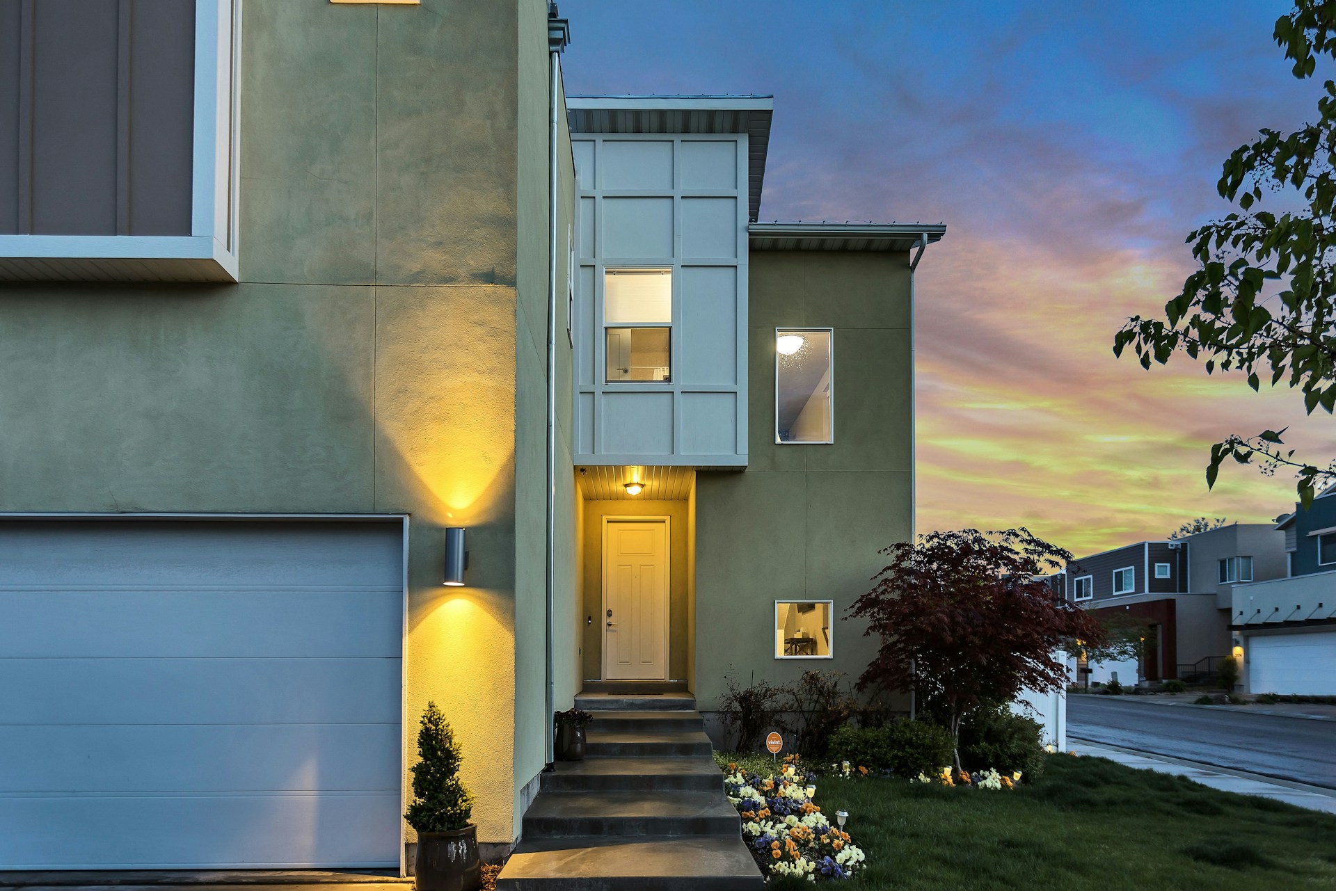 A home in the evening with outside lights. Which electricity saving tips will cut your home bills the most?